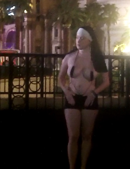This nearly Topless Busker dressed like a Nun is offensive to most Visitors but some are all more than willing to give Her money for a picture.
